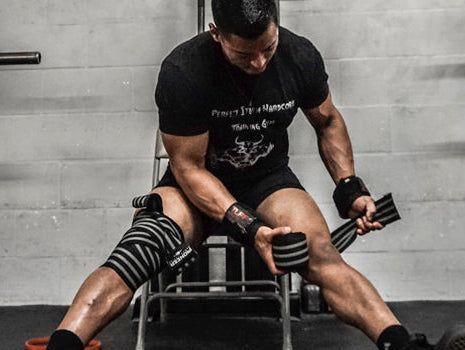 Aging powerlifter wrapping knees