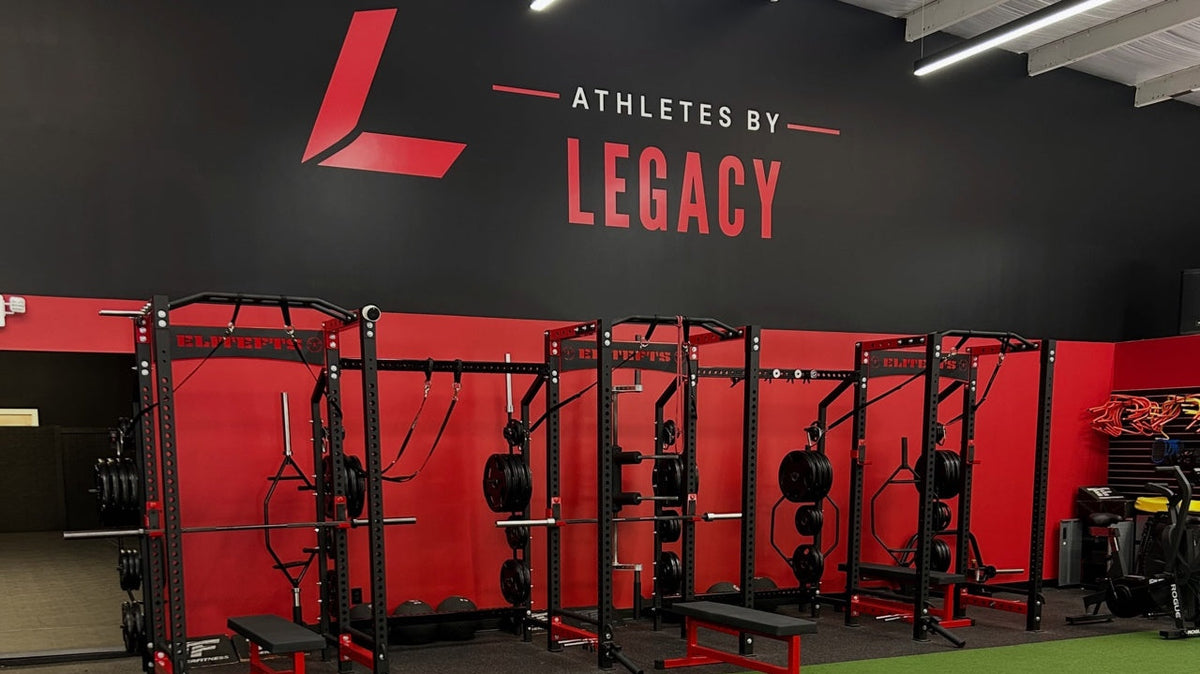 Red and black training racks beside green turf at Athletes By Legacy in Franklin, Tennessee