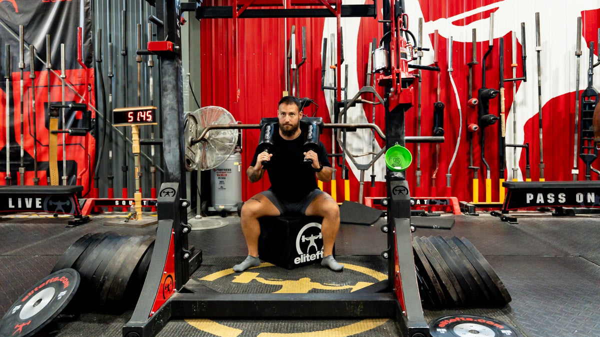 Lifter using the elitefts Squat Box with a safety squat bar in the elitefts gym