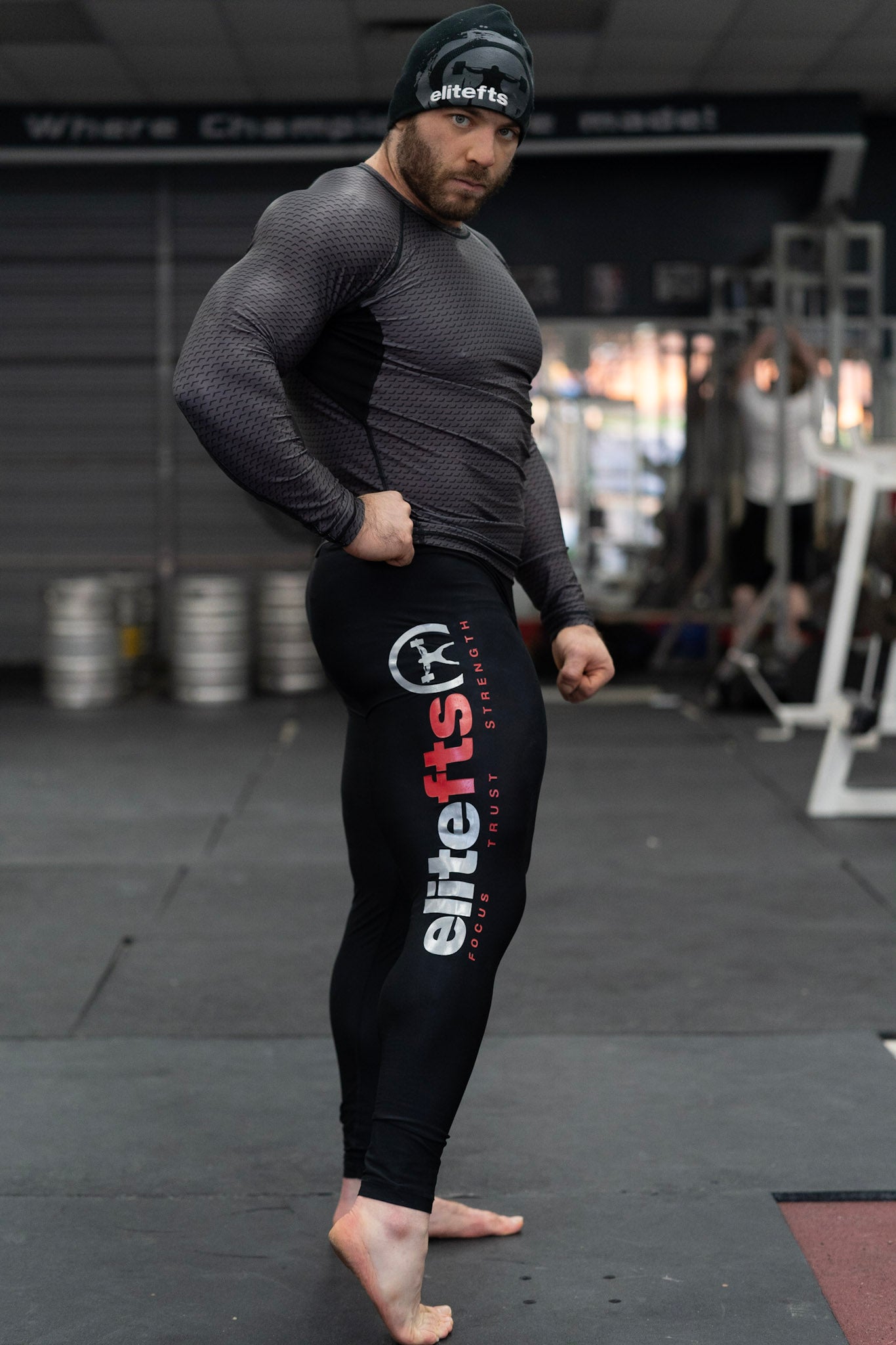 a pair of black compression pants with a decal on the side being worn by someone looking at the camera