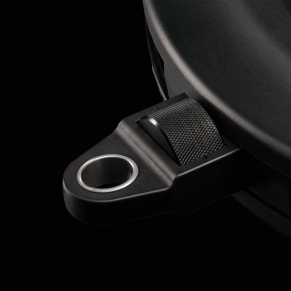 Close-up of a black metal bracket with a circular hole on a black background