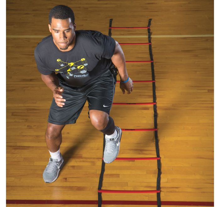 Man running through a ladder on a wooden floor