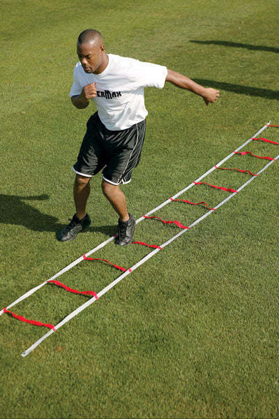 Man using a ladder drill on a grass field