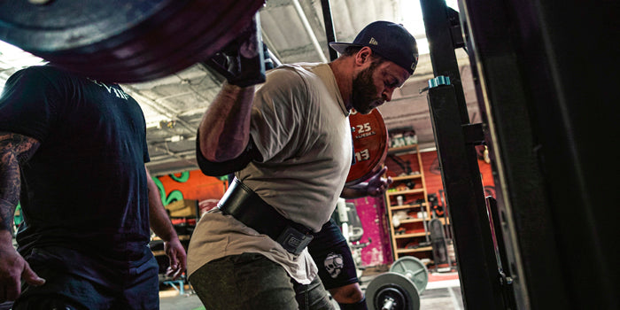 guy getting his breath before squatting with barbell
