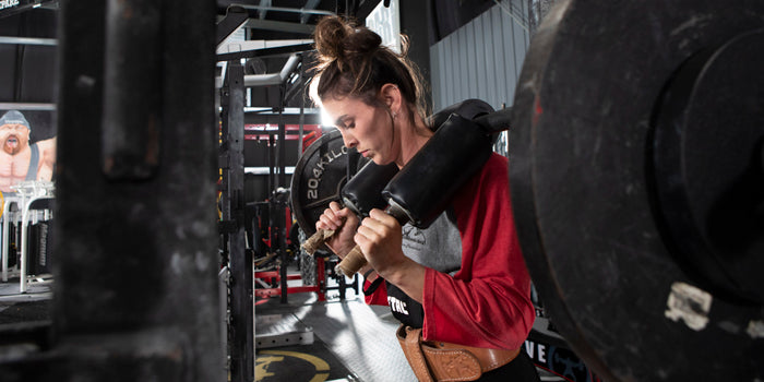 girl squatting with safety squat bar