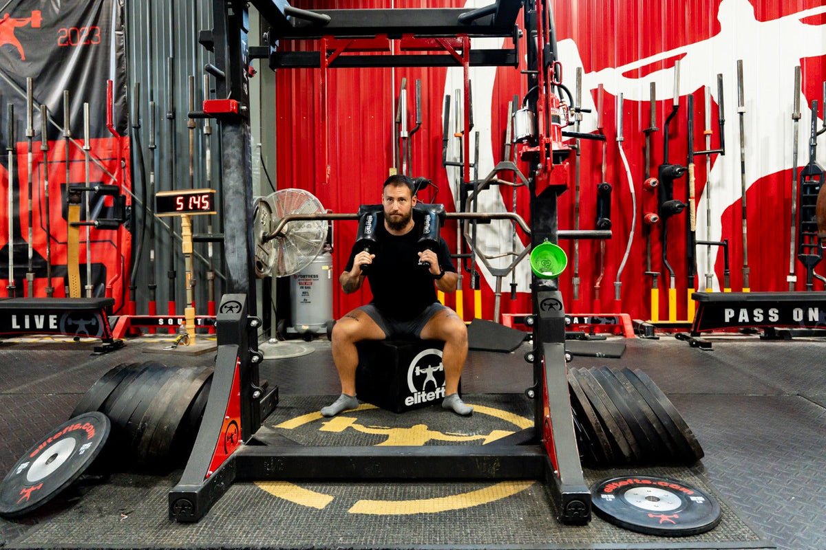 Lifter using the elitefts Squat Box with a safety squat bar in the elitefts gym