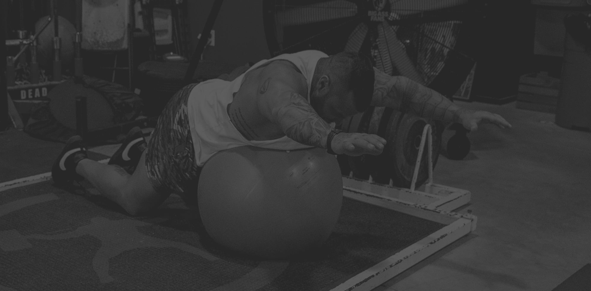 Man laying on a ball with his hands up 