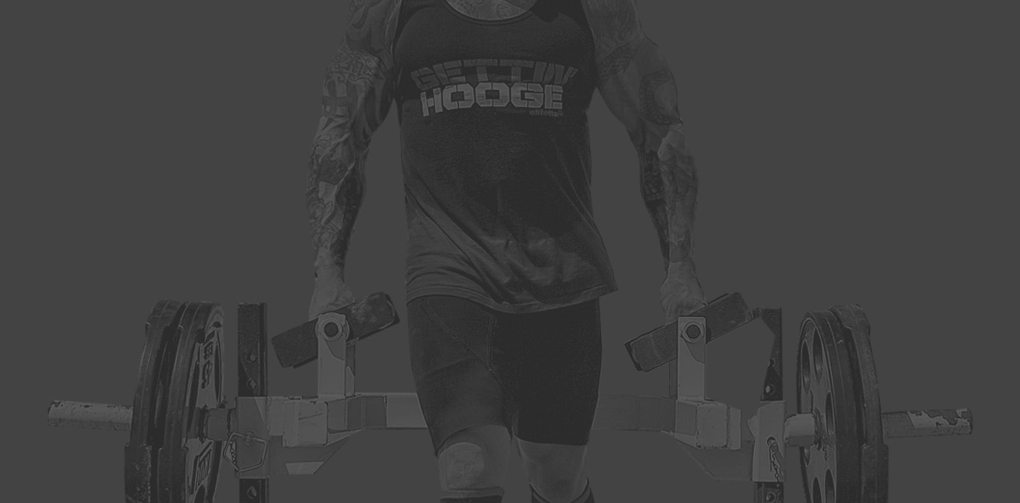 Man lifting a plate loaded strongman rack 