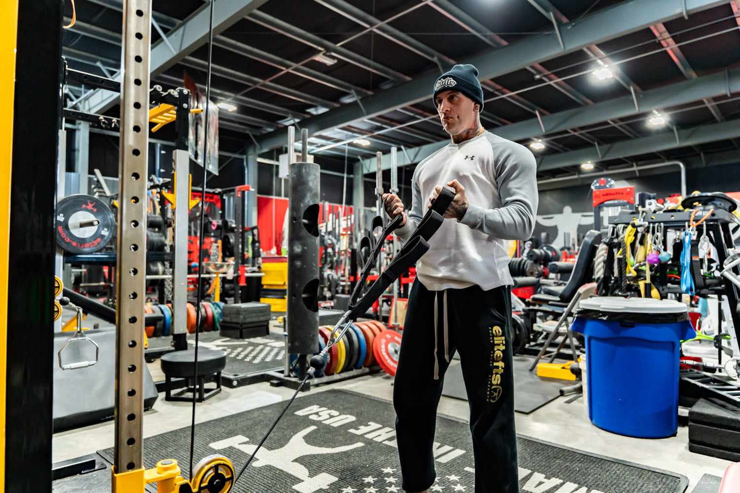 Person using resistance bands in a gym setting with various equipment around