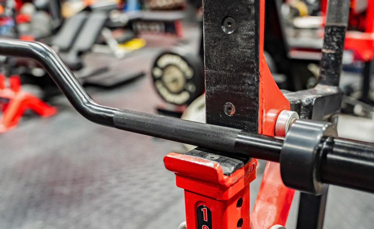Close-up of a barbell on a red weight bench in a gym setting