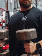 Person holding two dumbbells in a gym setting
