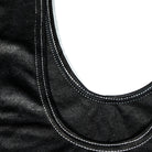 Close-up of black fabric with white stitching on a white background
