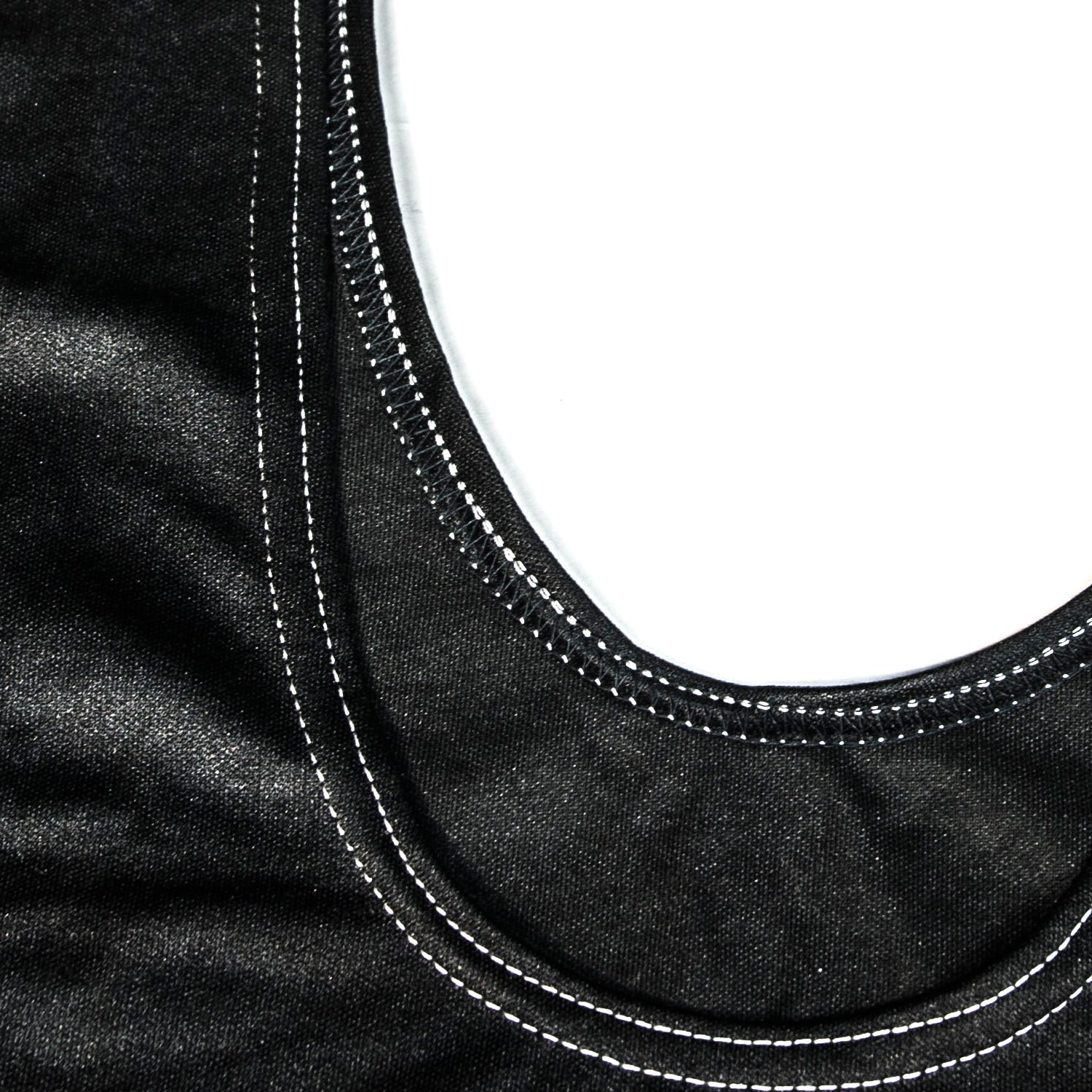Close-up of black fabric with white stitching on a white background