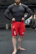someone wearing a pair of red compression shortswith EliteFTS decals on various parts of the product