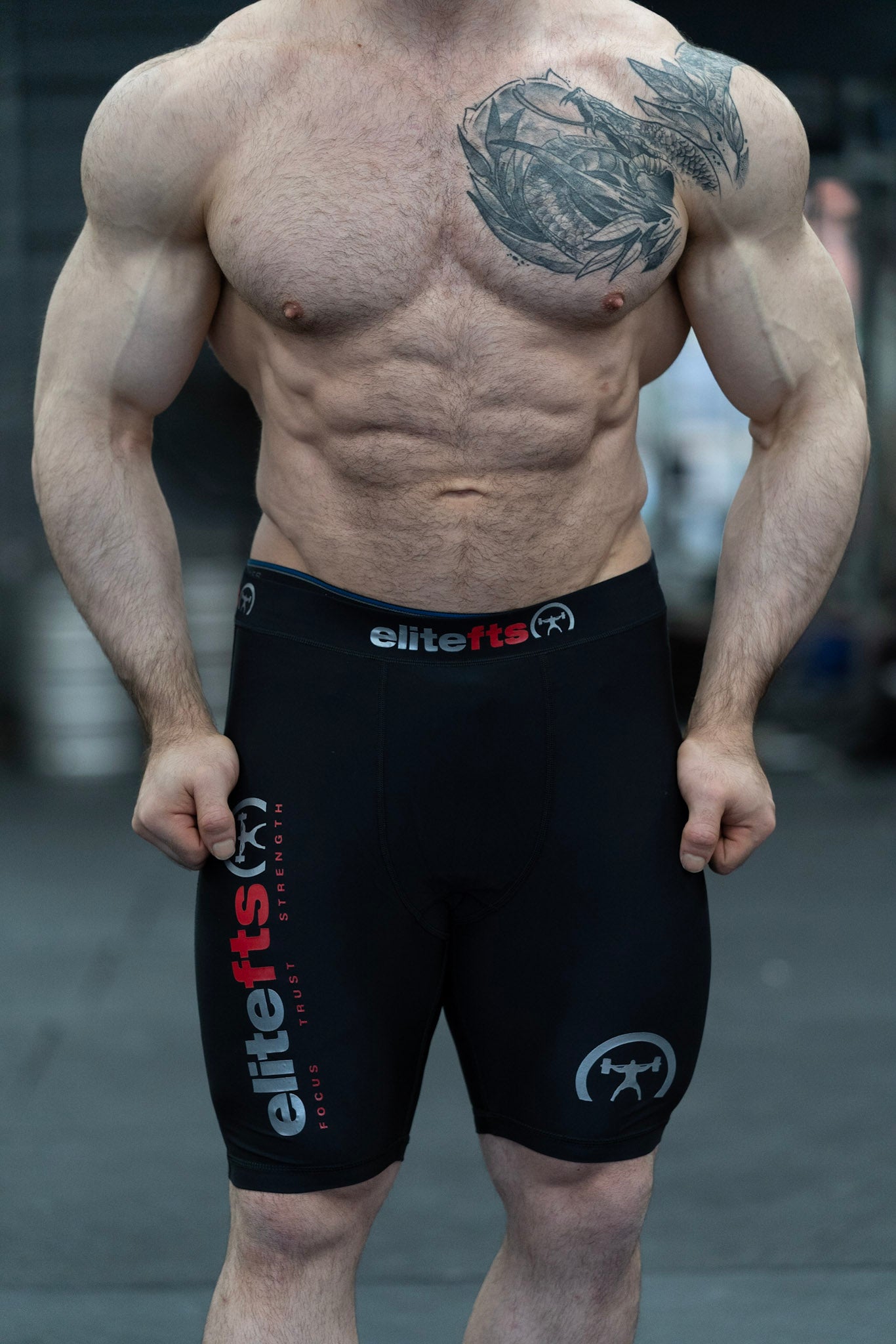 someone wearing a pair of black compression shortswith EliteFTS decals on various parts of the product