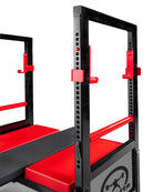 Black and red weightlifting power rack with red padding on a white background