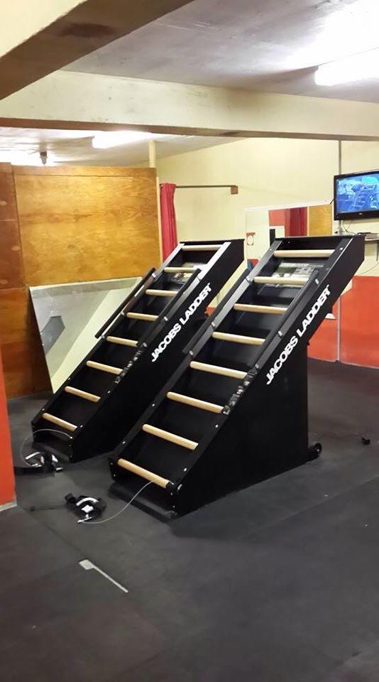 Two black and wooden models on display stands in a room with a TV in the background.