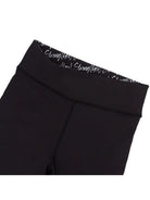 Black leggings with text on the waistband against a white background