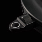 Close-up of a black metal bracket with a circular hole on a black background