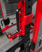 Close-up of a red and black weightlifting rack with visible bolts.