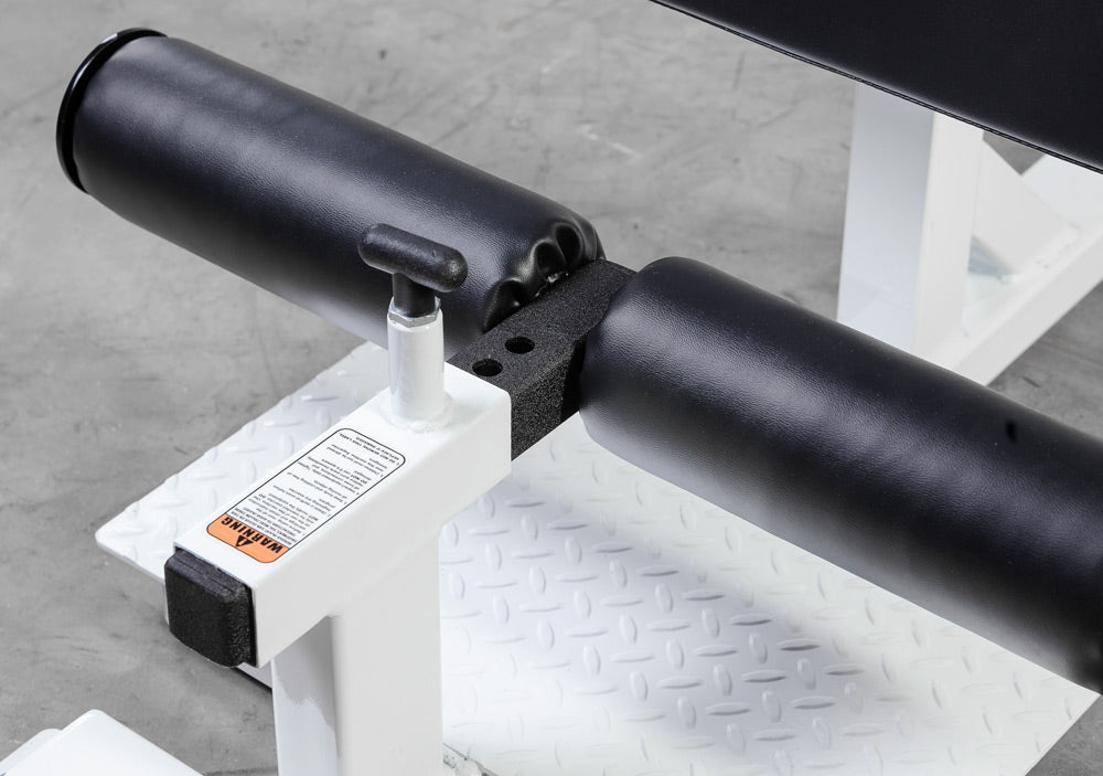 Close-up of a black metal rod or pipe on a white stand with a gray floor background