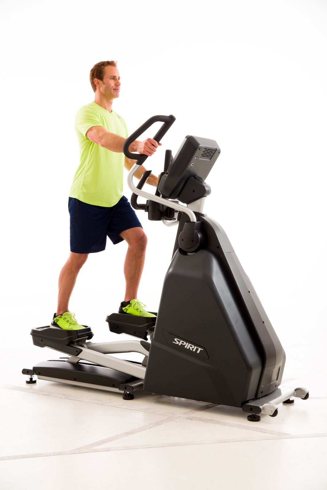Man exercising on a Spirit brand elliptical machine against a white background