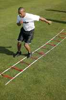 Man using a ladder drill on a grass field