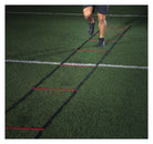 Person using a ladder drill on a green sports field